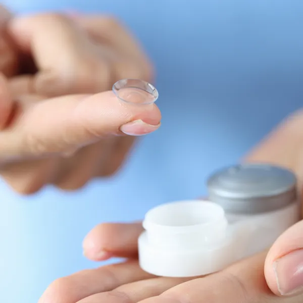 A soft contact lens resting on a fingertip