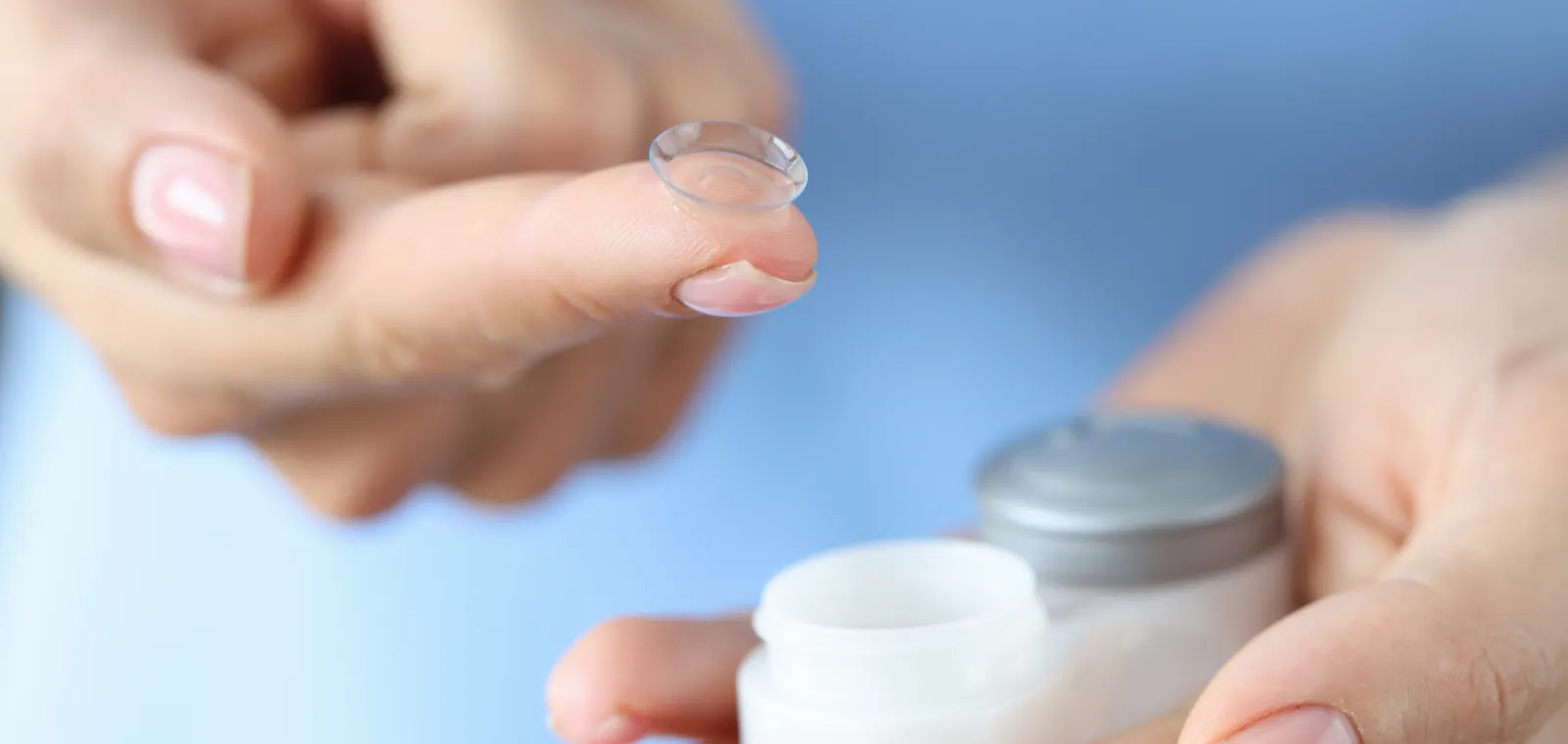 A soft contact lens resting on a fingertip