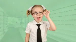A young girl smiling and adjusting her new glasses