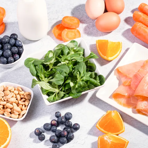 A spread of eye-healthy foods including leafy greens, salmon, and citrus