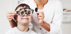 A young boy having his eyes tested with a trial frame at Outlook Eye Centre