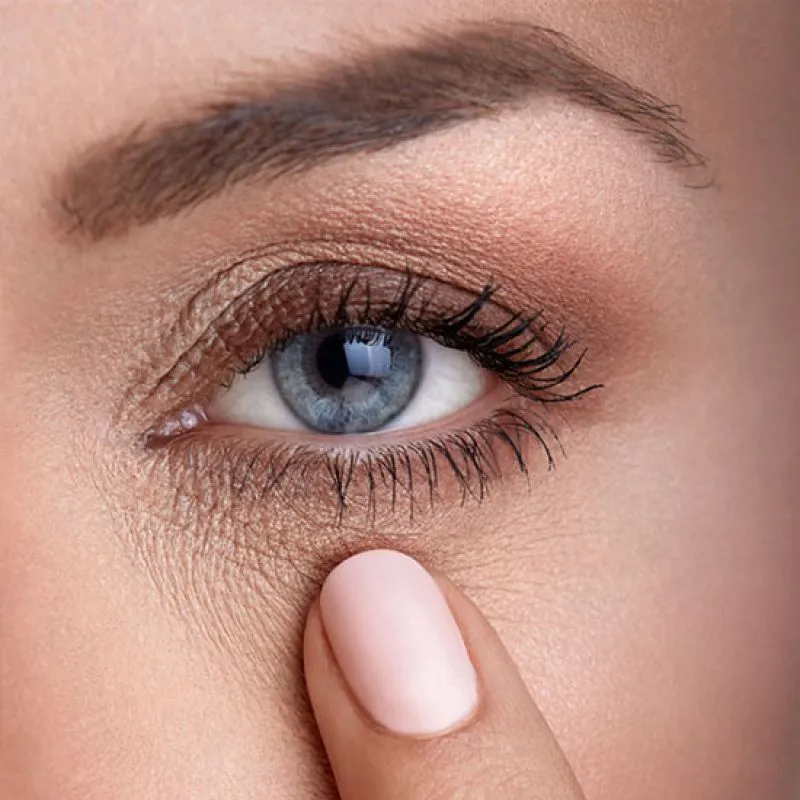 A close-up of a blue eye with a fingertip resting beneath it